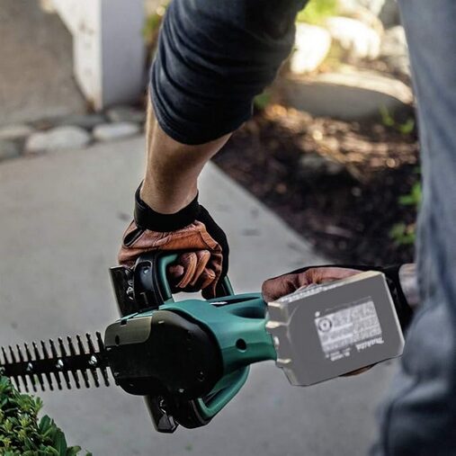 Makita XHU02Z 18V LXT® Lithium-Ion Cordless 22" Hedge Trimmer Review 5 A person using a hedge trimmer - Makita XHU02Z 18V LXT