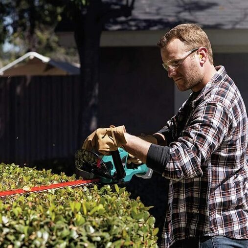 Makita XHU02Z 18V LXT® Lithium-Ion Cordless 22" Hedge Trimmer Review 6 A person cutting a hedge - Makita XHU02Z 18V LXT